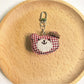 Bear charm keychain hanging from a car rearview mirror
