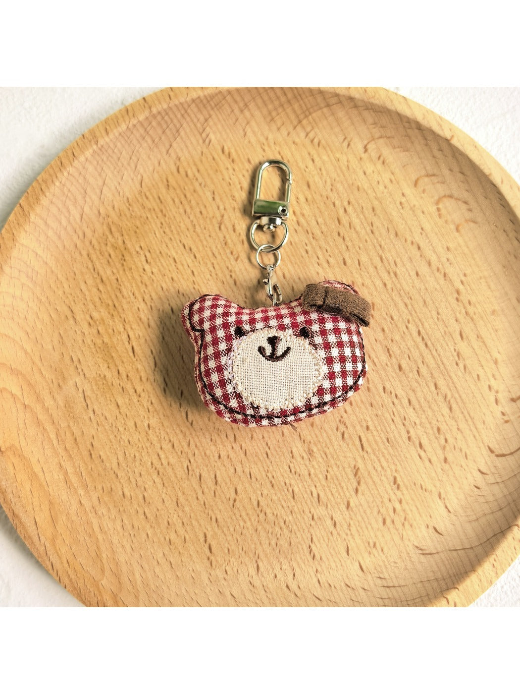 Bear charm keychain hanging from a car rearview mirror