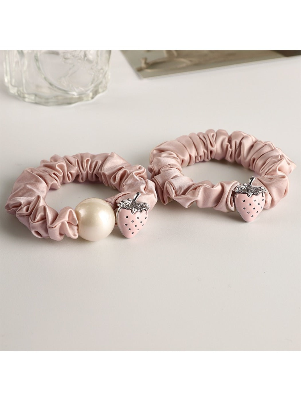 Strawberry hair tie wrapped around a ponytail on a model's hair