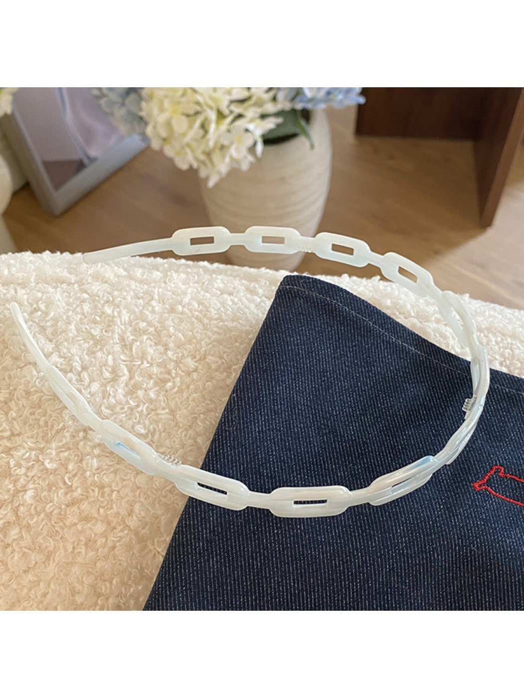 Top view of Gifty acetate chain style headband displaying smooth curved shape