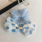 Chic hair tie with black and white polka dot bow on a white background