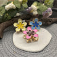 Close-up of Beau lively sunny flower hair clip with yellow petals and green leaves