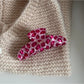 Beau pink leopard print hair clip clipped onto a section of hair