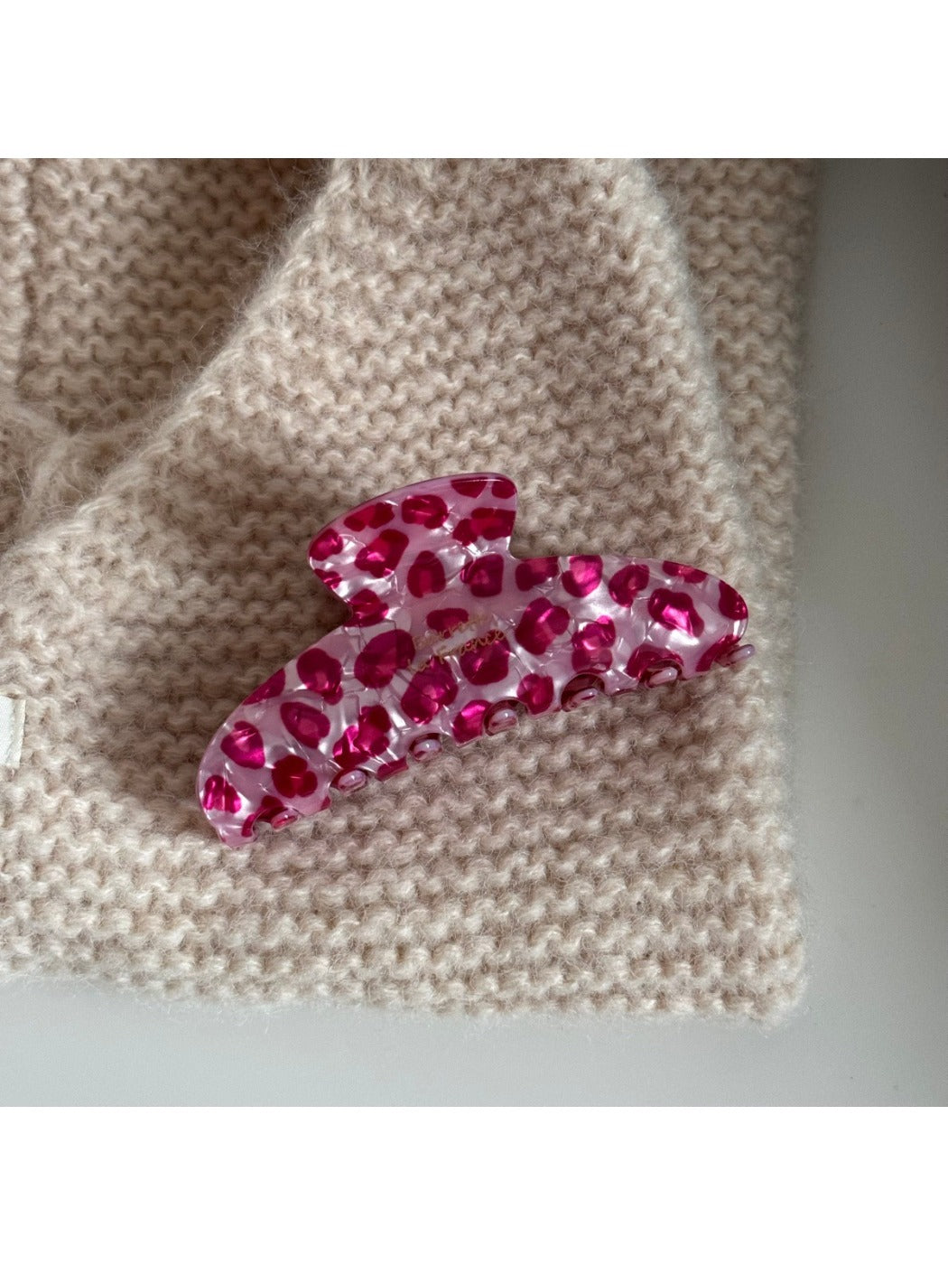 Beau pink leopard print hair clip clipped onto a section of hair
