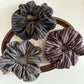 Gifty dark scrunchie with subtle stripes displayed flat
