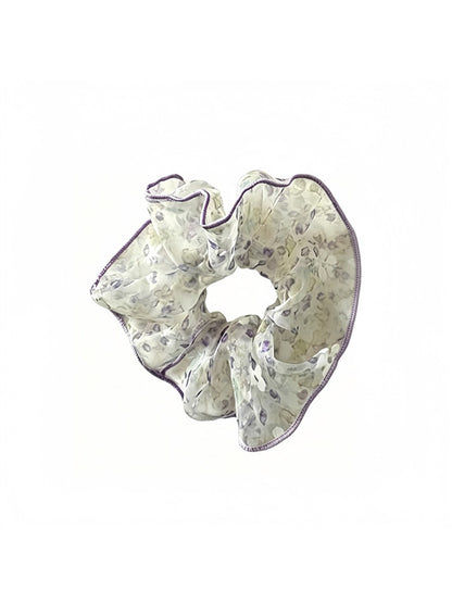 Gifty sheer tulle scrunchie displayed on a flat surface, showcasing its translucent fabric and floral print