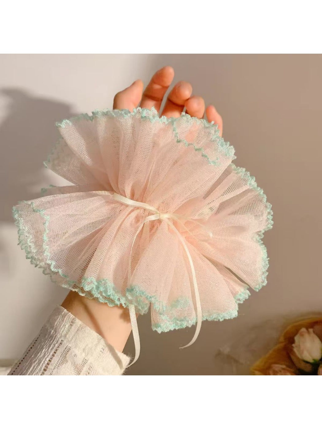Gifty ruffle scrunchie styled on a wrist with delicate ruffled edges