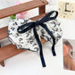 Beau Chic Sweet Bow Hair Clip displayed on a wooden surface with soft lighting