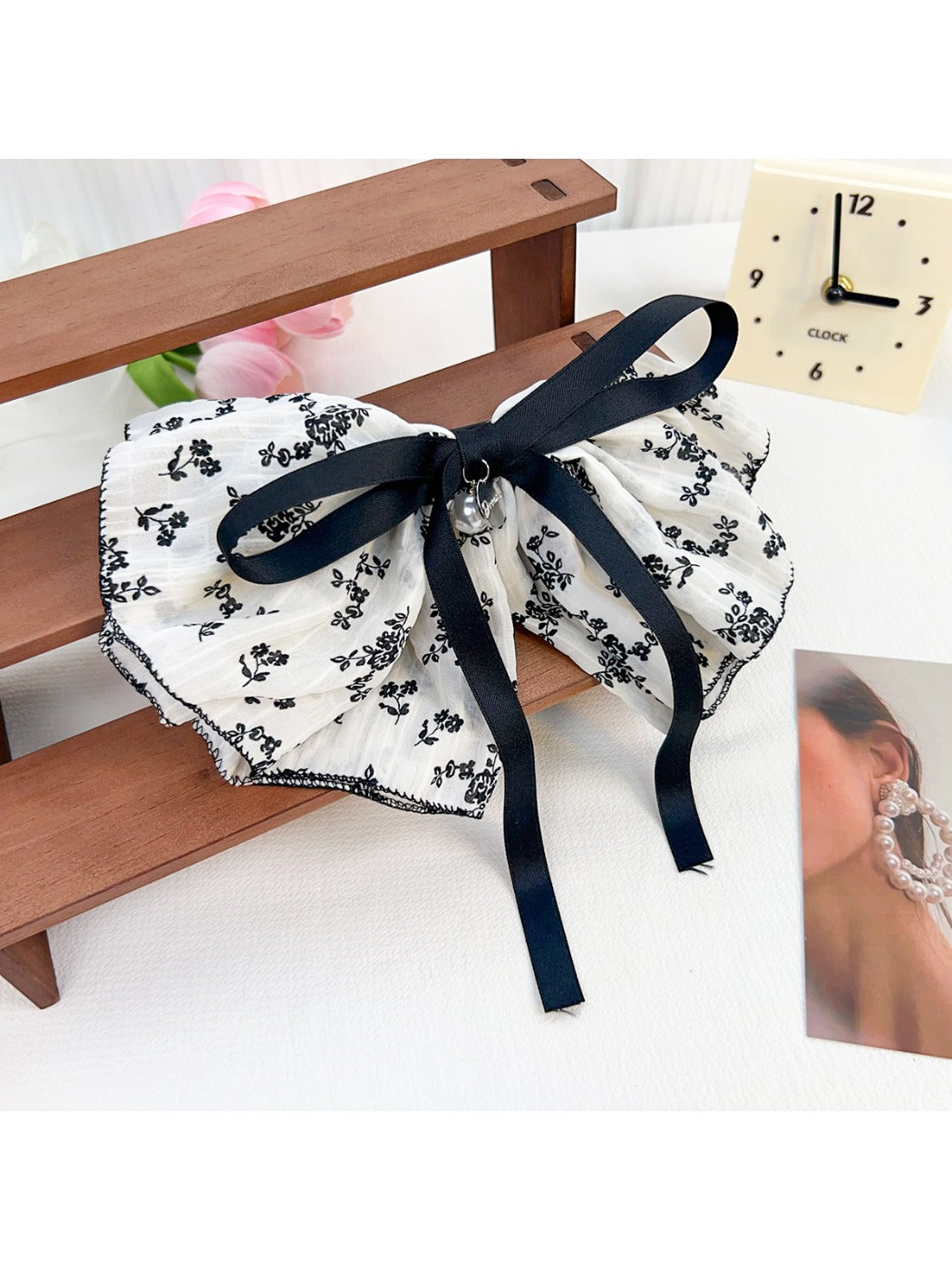 Beau Chic Sweet Bow Hair Clip displayed on a wooden surface with soft lighting