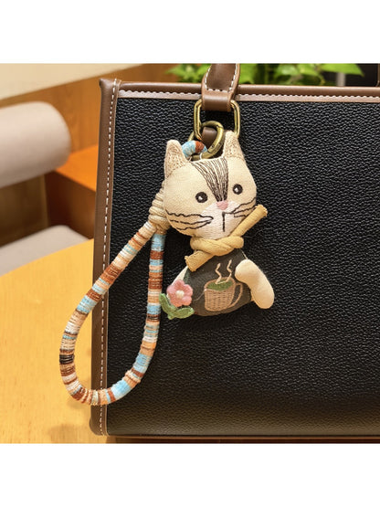 Vintage cat charm keychain displayed alongside keys on a flat surface