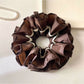Close-up of Gifty vintage dark double layered scrunchie on white background