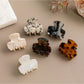 Side view of Beau hair clip displaying curved shape and clasp mechanism