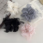 Close-up of Gifty stylish scrunchie with bow accent in soft pink fabric
