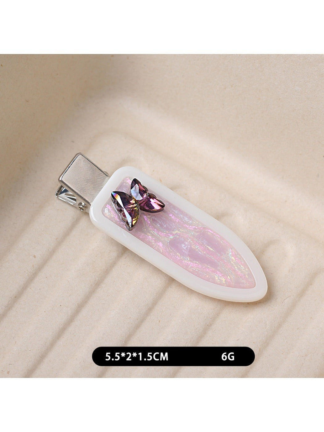 Beau acetate hair clip held in hand to show size and oval butterfly shape