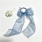 Plaid tulle bow hair tie styled in a ponytail on a model with brown hair
