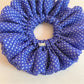 Blue polka dot scrunchie styled on a wrist as an accessory