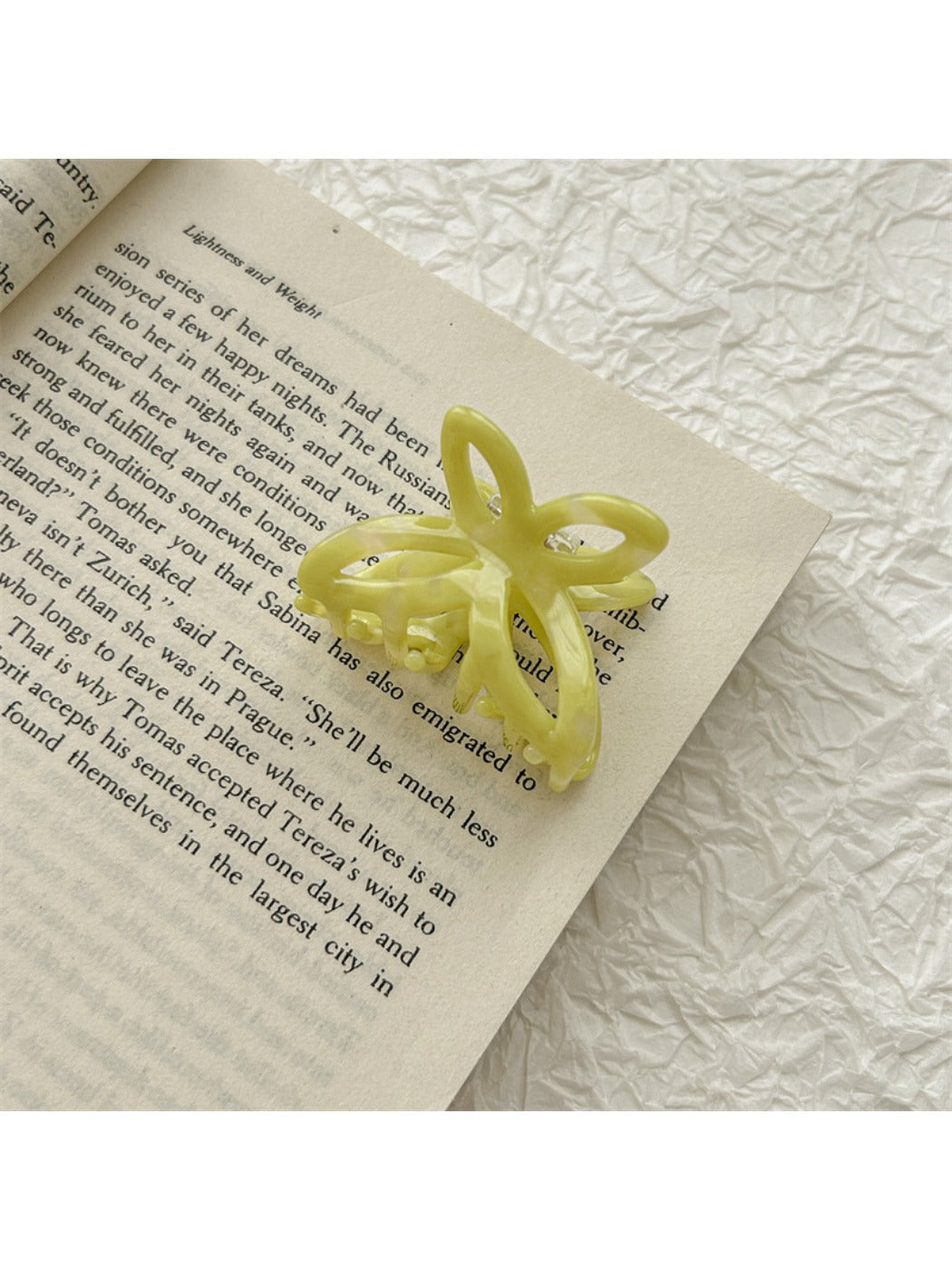 Beau acetate butterfly claw clip resting on white surface with soft lighting