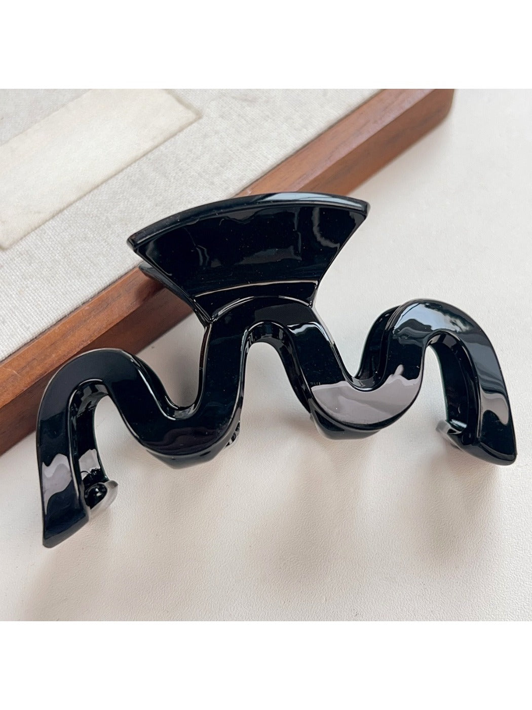 Top view of Beau wave-shaped hair claw clip showing curved teeth
