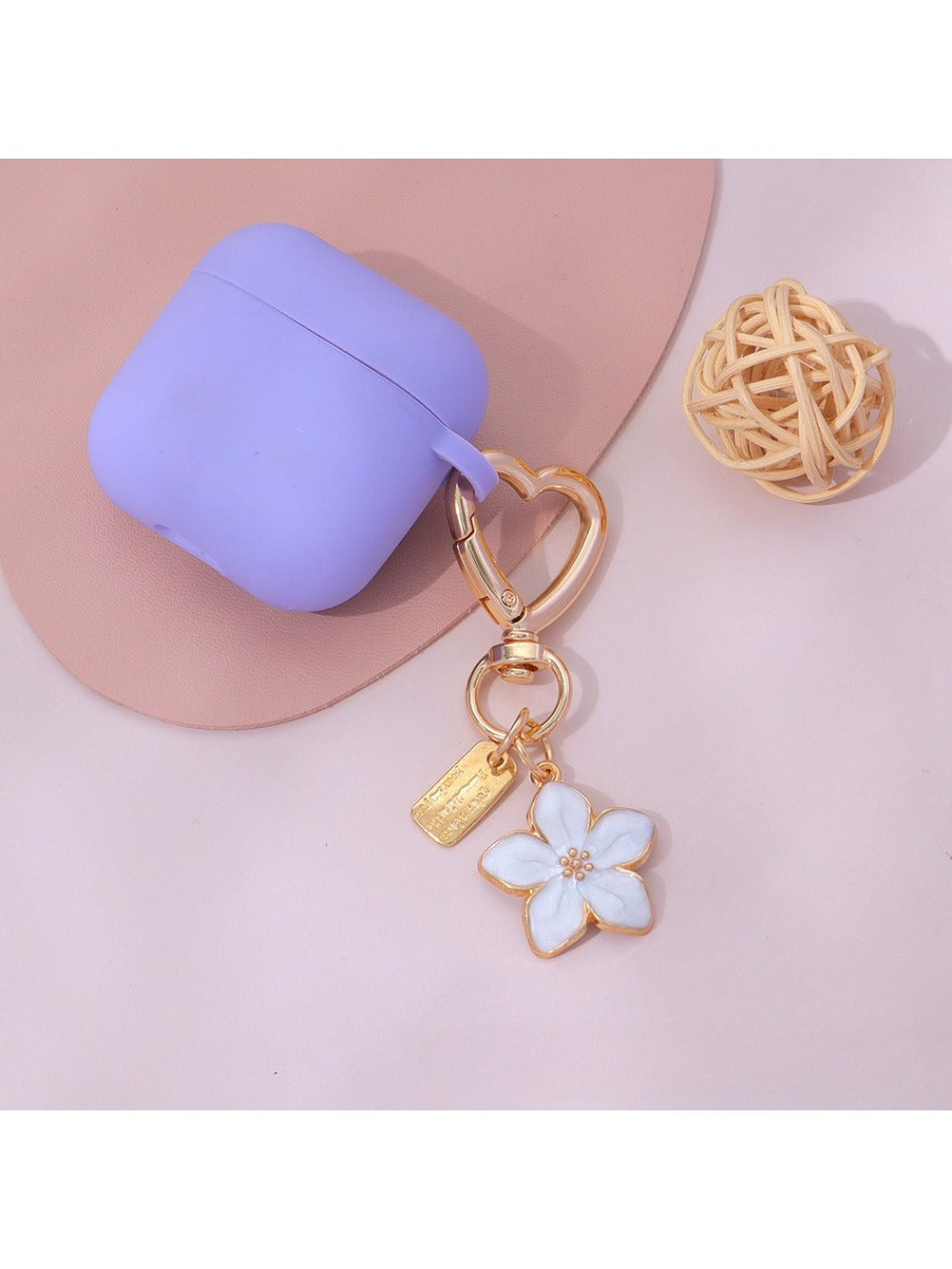 Keypus keychain with pink flower charm attached to a handbag zipper