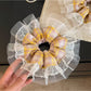 Yellow plaid scrunchie styled in a ponytail on a model