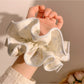 Gifty scrunchie worn on wrist displaying double layer design and cartoon print
