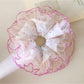Close-up of ruffled fabric with multicolored polka dots on scrunchie