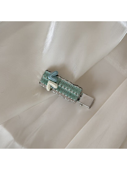 Beau chic flat hair clip resting on a textured fabric surface