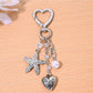 Hand holding the starfish shaped heart keychain with natural lighting