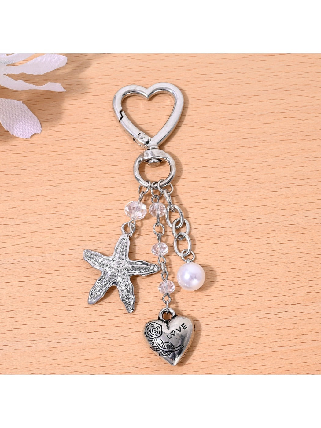 Hand holding the starfish shaped heart keychain with natural lighting
