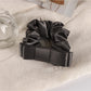Soft romantic scrunchie styled in loose hair bun with subtle floral accents
