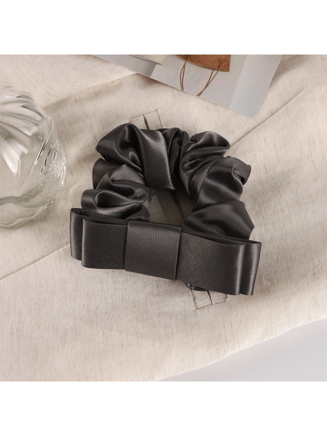 Soft romantic scrunchie styled in loose hair bun with subtle floral accents