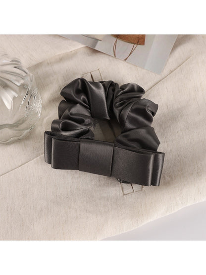 Soft romantic scrunchie styled in loose hair bun with subtle floral accents
