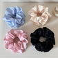 Close-up of Gifty Sweet Style floral print scrunchie with pink and white flowers on fabric