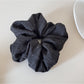 Gifty scrunchie wrapped around a ponytail on a model with brown hair