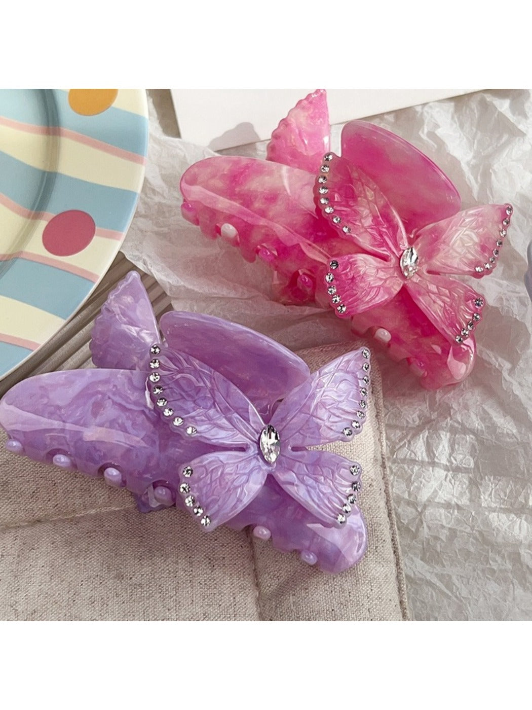 Beau hair claw clip held in hand displaying size and butterfly decoration