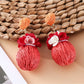 Earedge fabric flower raffia ball earrings displayed on a jewelry stand