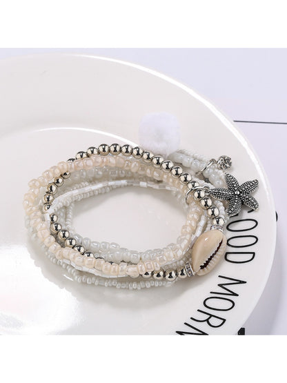 Lovra bracelet worn on wrist with layered small gold and silver beads