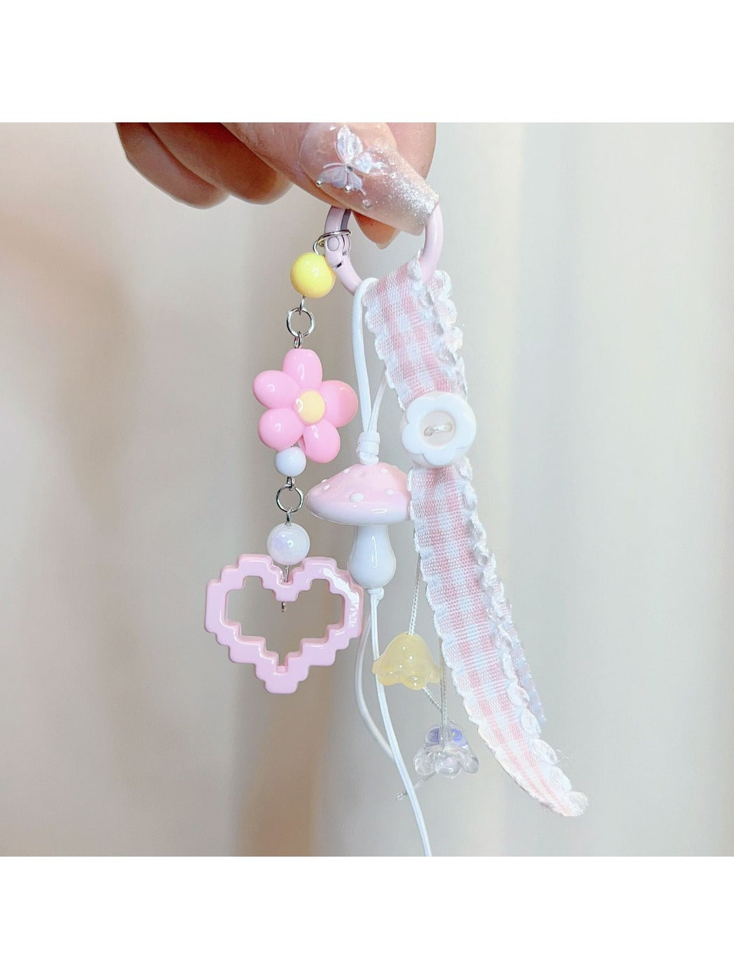 Pink mushroom keychain displayed against a white background with soft shadows