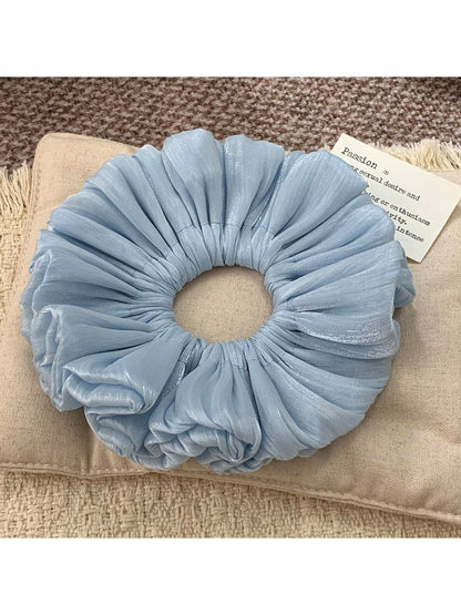 Solid color satin scrunchie stretched slightly to show fabric quality