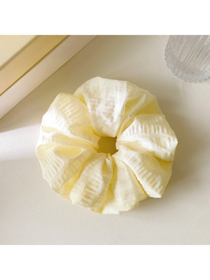 Gifty scrunchie wrapped around a ponytail, highlighting its stretch and colorful design