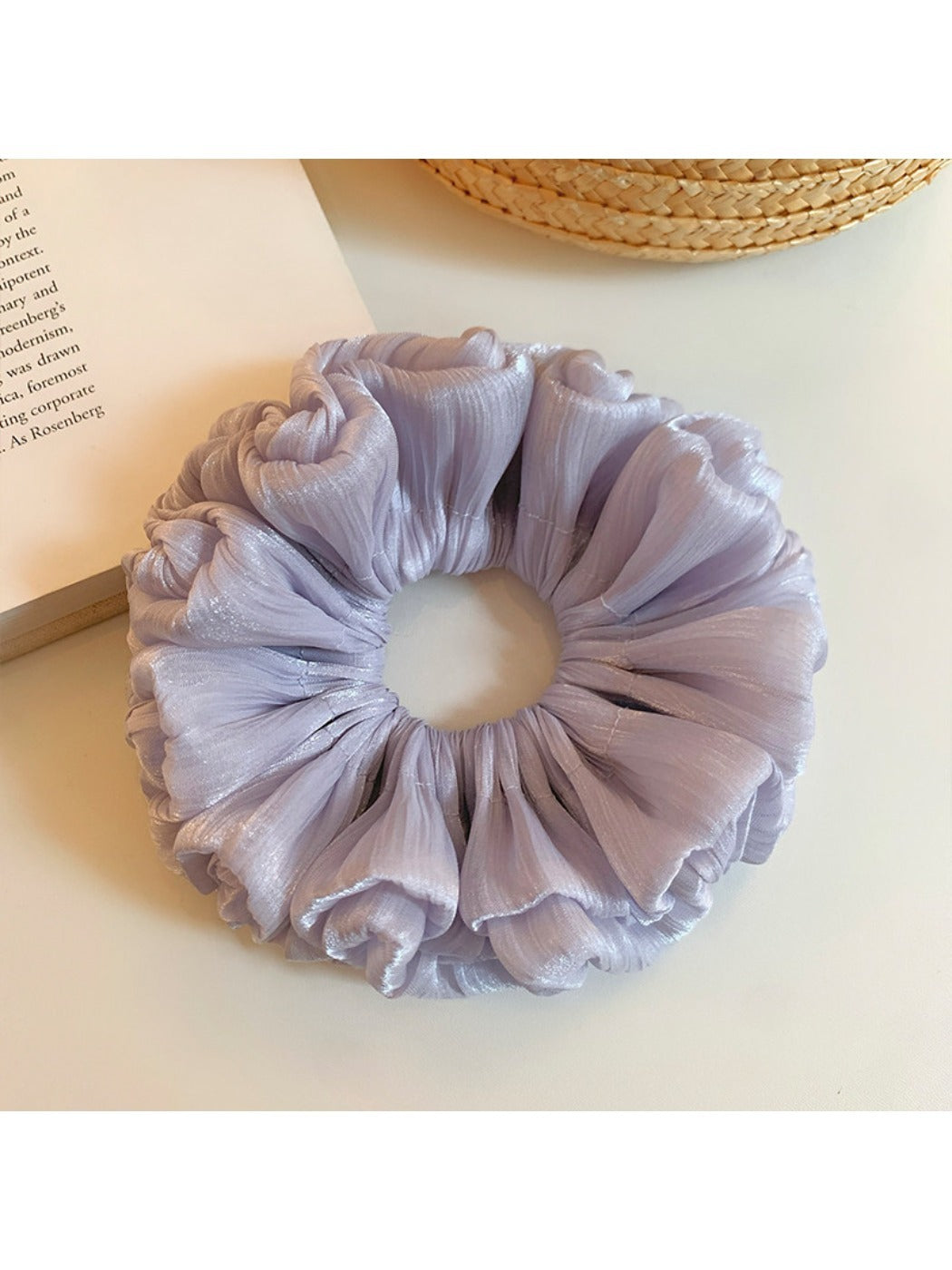 Purple reflective tulle scrunchie styled on a wrist with soft lighting