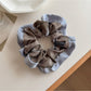 Flat lay of Gifty color block print scrunchie alongside matching hair accessories