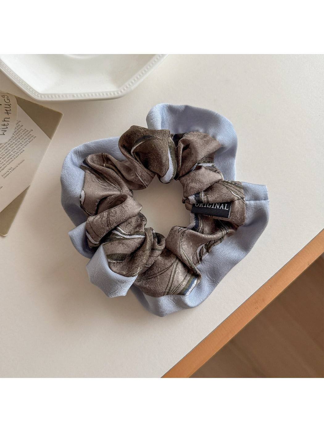 Flat lay of Gifty color block print scrunchie alongside matching hair accessories