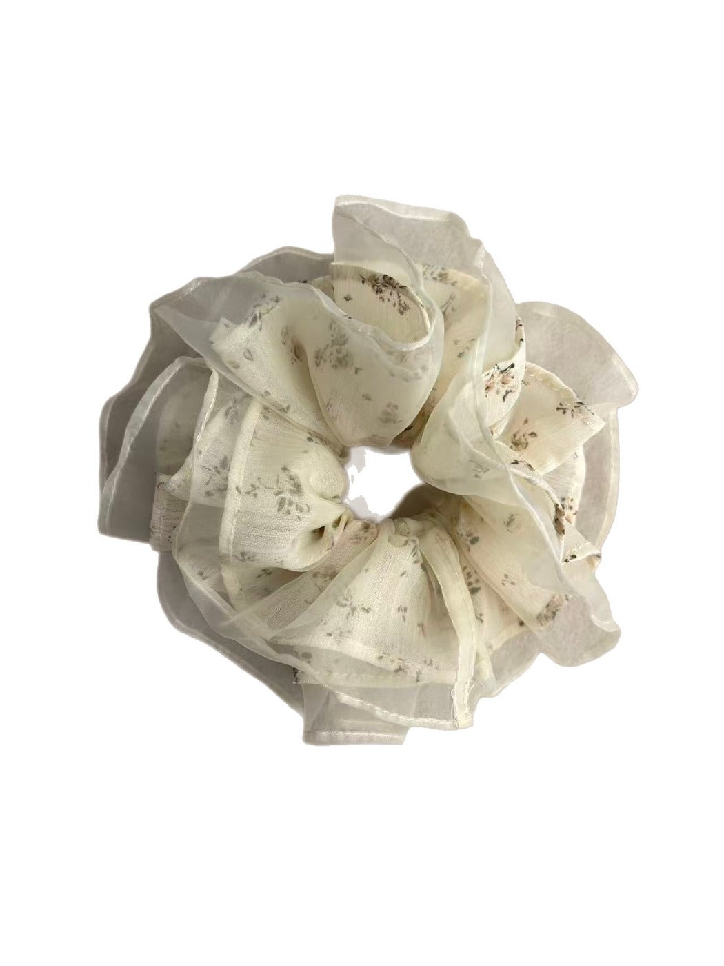 Close-up of delicate white tulle fabric scrunchie featuring small floral prints