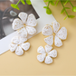 Earedge floral pendant raffia drop earrings photographed on a marble surface