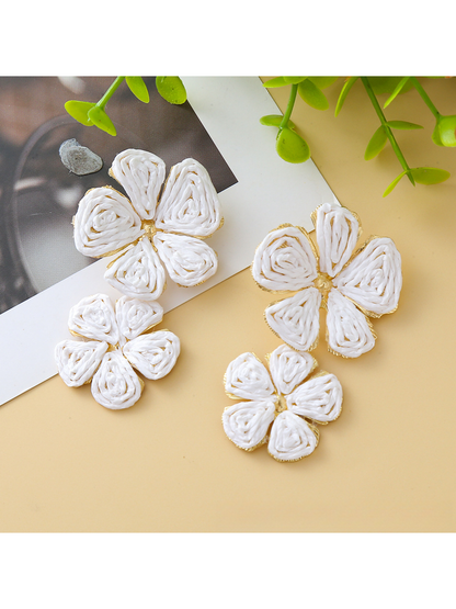 Earedge floral pendant raffia drop earrings photographed on a marble surface
