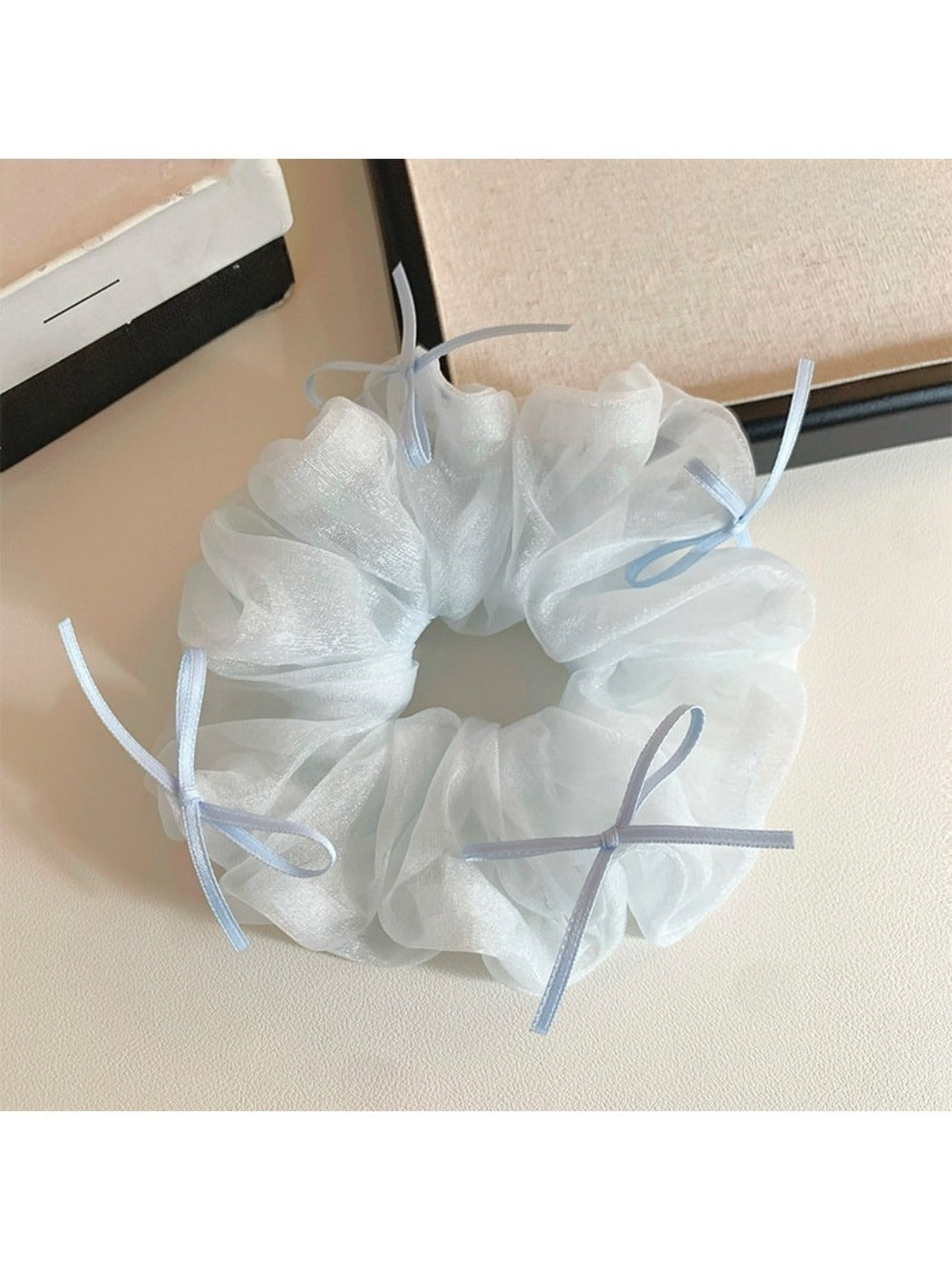 Blue tulle scrunchie with ribbon bow against white background showing full design