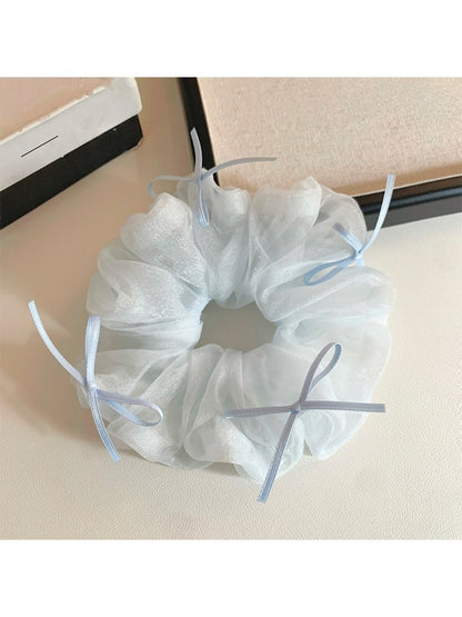Blue tulle scrunchie with ribbon bow against white background showing full design