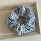 Side view of beige dot cutout scrunchie highlighting fabric layers and texture