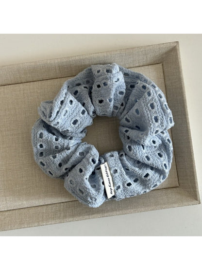 Side view of beige dot cutout scrunchie highlighting fabric layers and texture